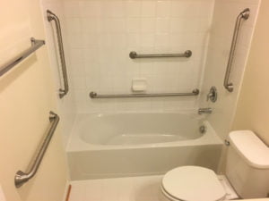 Photo of a bathtub with several handrails that aid in getting into a tub and maneuvering inside