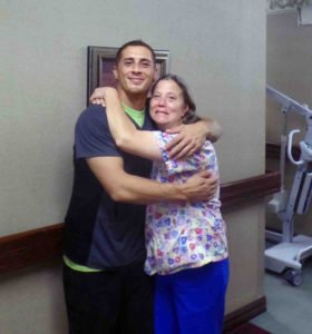 Photo of 2 nursing home staff hugging in the hallway